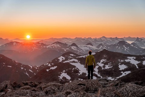 Mountaineer enjoying the view, mountain panorama at the summit of Skala at sunset, sun setting