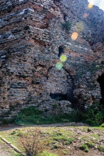 Interior stone and brick wall of castle ruins with lens flares across facade in Istanbul, Tuerkiye