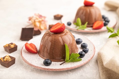 Chocolate jelly with strawberry and blueberry on gray concrete background and linen textile. side