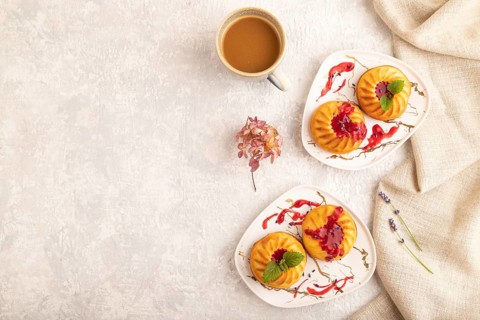 Semolina cheesecake with strawberry jam, lavender, cup of coffee on gray concrete background and