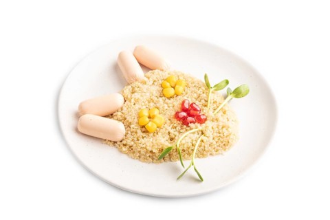 Funny mixed quinoa porridge, sweet corn, pomegranate seeds and small sausages in form of cat face