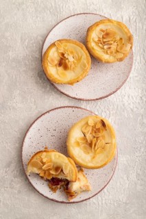Traditional portuguese cakes pasteis de nata, custard small pies with almonds on gray concrete