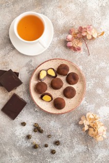 Japanese rice sweet buns chocolate mochi filled with cream and cup of green tea on brown concrete