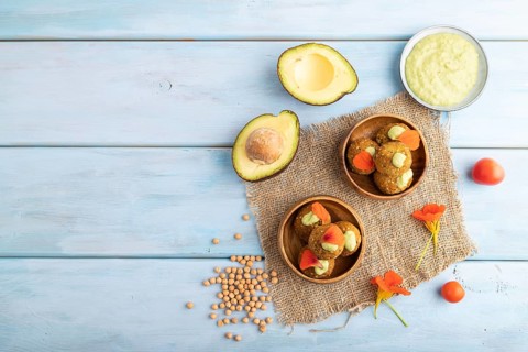 Falafel with guacamole on blue wooden background and linen textile. Top view, flat lay, copy space