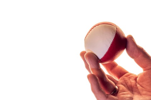 Hand with a juggling ball in front of a white background, studio shot, Germany, Europe