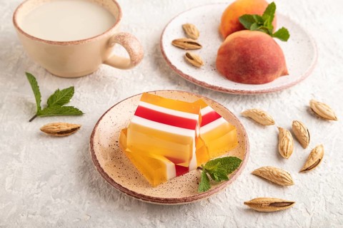 Almond milk and peach jelly on gray concrete background. side view, close up