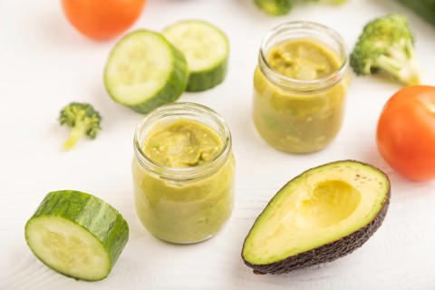 Baby puree with vegetable mix, broccoli, tomatoes, cucumber, avocado infant formula in glass jar on