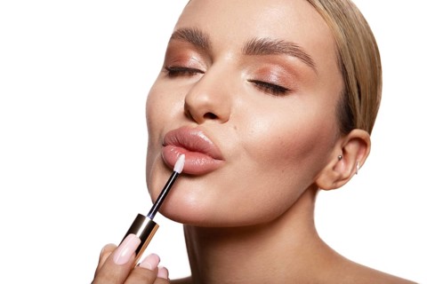 Beauty portrait of model with natural make-up holding a jar of cream. Fashion shiny highlighter on