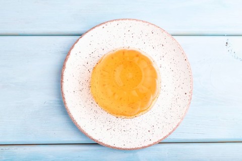 Apricot orange jelly on blue wooden background. top view, flat lay, close up