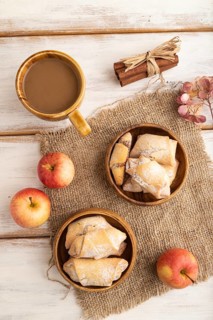Homemade sweet cookie with apple jam and cup of coffee on white wooden background and linen textile