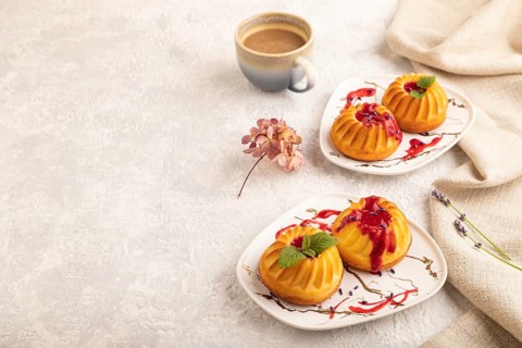 Semolina cheesecake with strawberry jam, lavender, cup of coffee on gray concrete background and