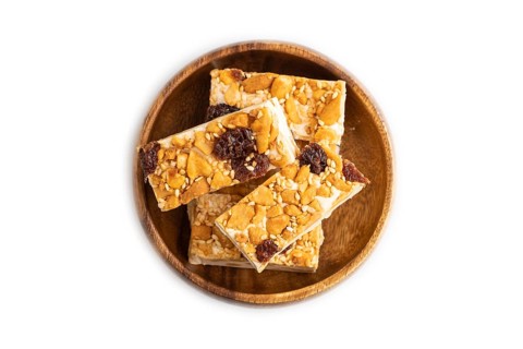 Traditional candy nougat with nuts and sesame isolated on white background. top view, flat lay,