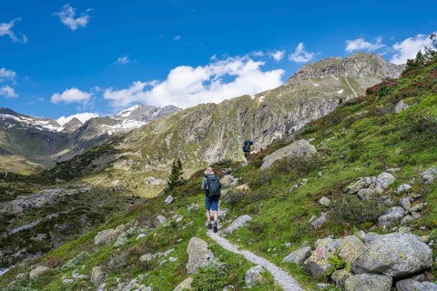 Mountaineers on a hiking trail in front of a picturesque mountain landscape, rocky mountain peaks