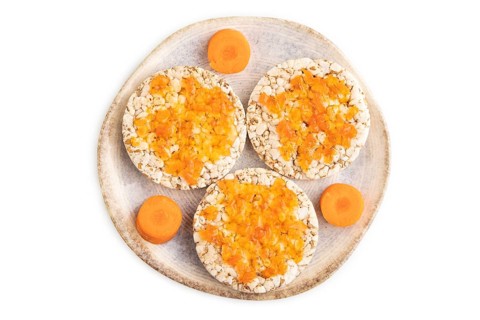 Carrot jam with puffed rice cakes isolated on white background. Top view, flat lay, close up