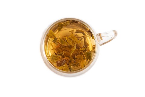 Red tea with herbs in glass cup isolated on white background. Healthy drink concept. Top view, flat