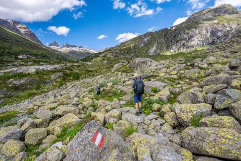 Mountaineers on a hiking trail in front of a picturesque mountain landscape, rocky mountain peaks