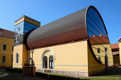 An unusual combination of modern glass architecture and traditional building elements under a clear