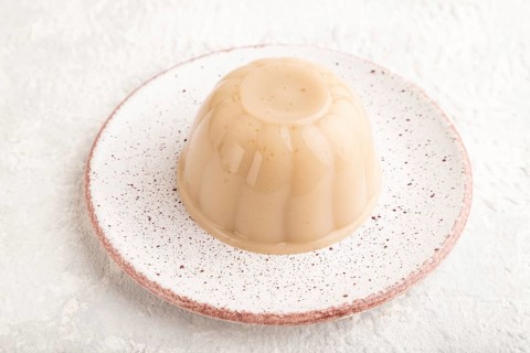 Buckwheat milk jelly on gray concrete background. side view, close up