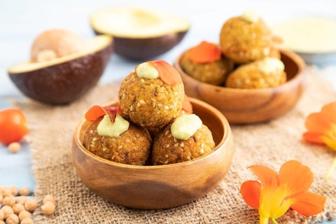 Falafel with guacamole on blue wooden background and linen textile. Side view, close up, selective