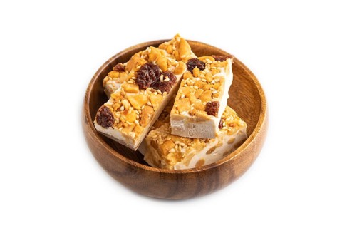 Traditional candy nougat with nuts and sesame isolated on white background. side view, close up