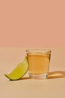 Tequila shot with lime under hard sunlight