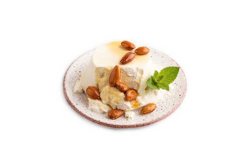 Ricotta cheese with honey and almonds isolated on white background. side view, close up