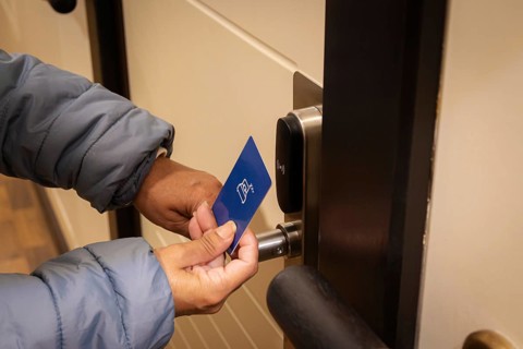 Woman hand using electronic smart key card to unlock door in hotel or house. Digital lock, door