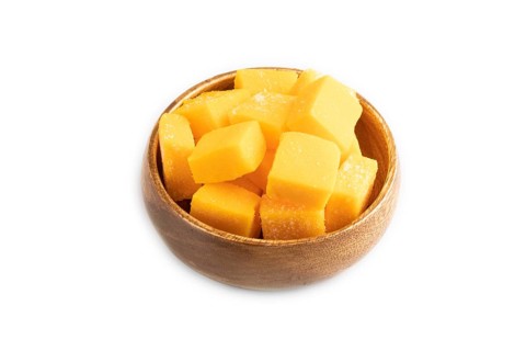 Dried and candied mango cubes in wooden bowls isolated on white background. Side view, close up,