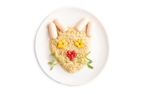 Funny mixed quinoa porridge, sweet corn, pomegranate seeds and small sausages in form of cat face