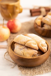 Homemade sweet cookie with apple jam and cup of coffee on white wooden background and linen textile
