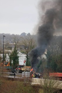 Farmers with tractors, craftsmen with vans and lorry drivers block the closed bridge Pont de