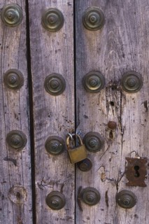 Antique wooden door with metal rivets and a padlock