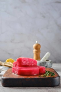Low angle view of raw ahi tuna steak on cutting board with spice