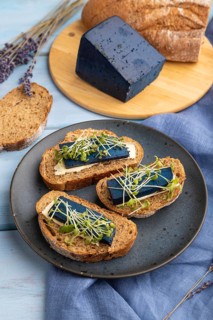 Bread sandwiches with blue lavender cheese and mustard microgreen on blue wooden background and
