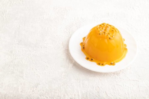 Mango and passion fruit jelly on gray concrete background. side view, copy space