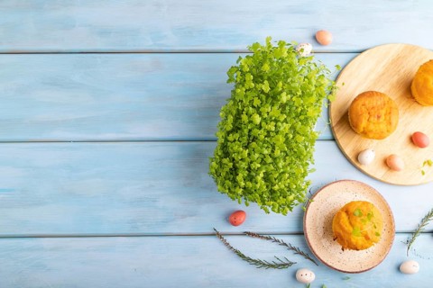 Homemade cakes with chocolate eggs and spinach microgreen on a blue wooden background. top view,