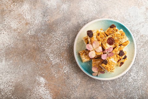 Traditional candy nougat with nuts and sesame on brown concrete background. top view, flat lay,