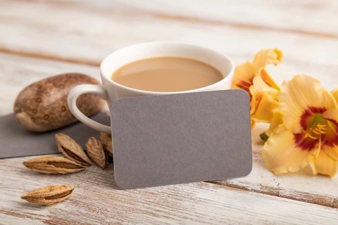 Gray paper business card mockup with orange day-lily flower and cup of coffee on white wooden