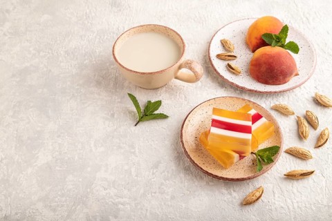 Almond milk and peach jelly on gray concrete background. side view, copy space