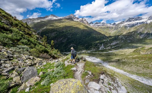 Mountaineers on a hiking trail in front of a picturesque mountain landscape, rocky mountain peaks