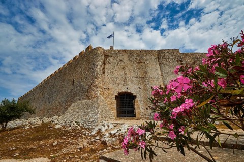 Stone fortress wall with blooming oleander in the foreground, Chlemoutsi, high medieval crusader