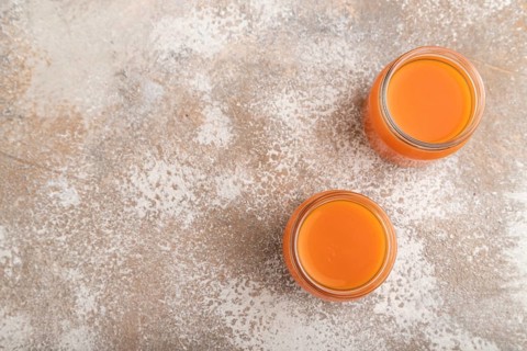 Baby puree with fruits mix, pumpkin, persimmon, mango infant formula in glass jar on brown concrete