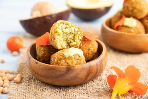 Falafel with guacamole on blue wooden background and linen textile. Side view, close up, selective