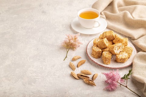 Traditional turkish delight (rahat lokum) with cup of green tea on a gray concrete background and