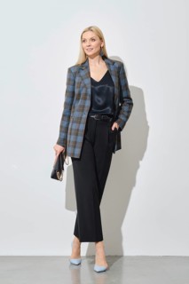 Modern businesswoman in stylish checkered jacket and loose trousers holding handbag