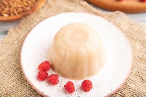 Buckwheat milk jelly on gray wooden background and linen textile. side view, close up, selective