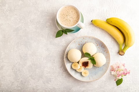 Japanese rice sweet buns mochi filled with jam and cup of coffee on a gray concrete background. top