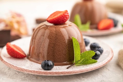 Chocolate jelly with strawberry and blueberry on gray concrete background and linen textile. side