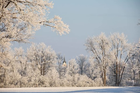Snowy, sunny winter landscape near Polling an der Ammer. View of the church tower of Oderding.