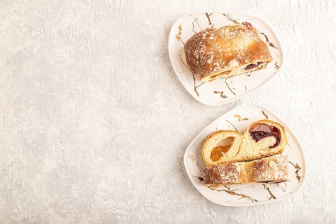 Homemade sweet bun with apricot jam on gray concrete background. top view, flat lay, copy space